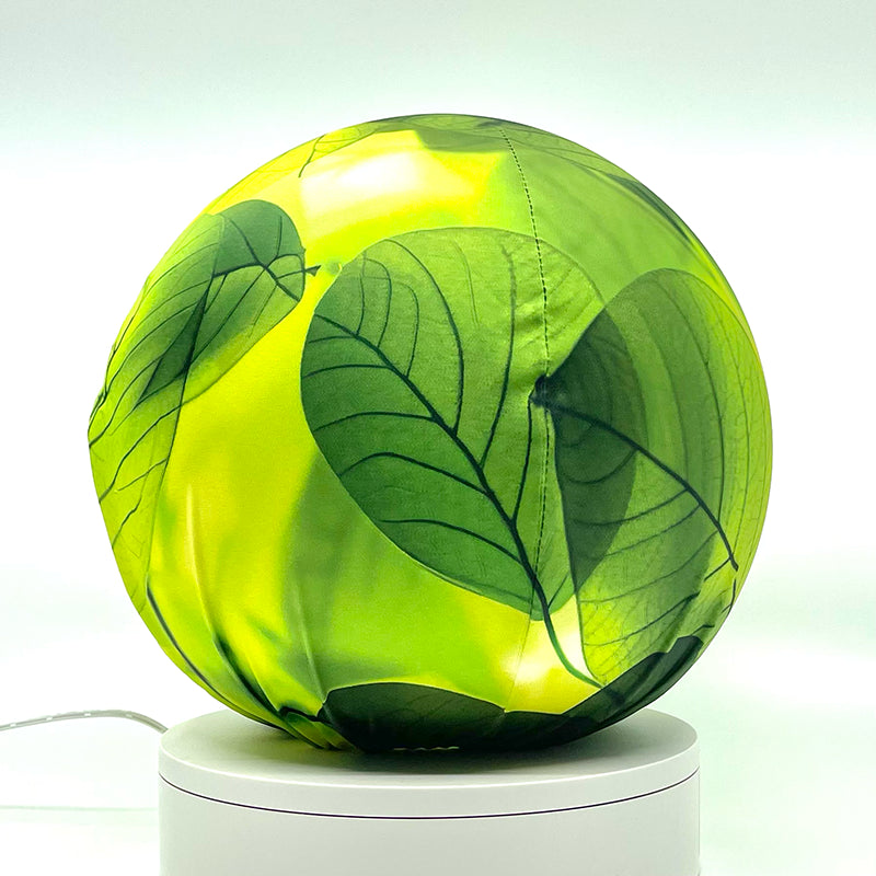 Fabric sphere cover with a close-up bright translucent leaf design, wrapped around a 8.7" soccer ball, 9.5" basketball ball, or a 10" globe.