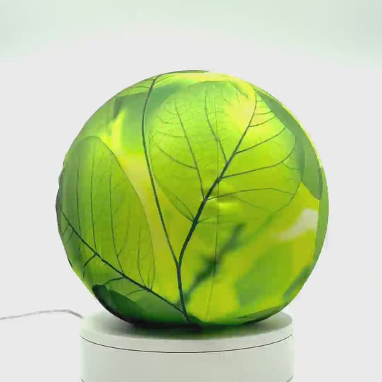 360°-rotating fabric sphere cover with a close-up bright translucent leaf design, wrapped around a 8.7" soccer ball, 9.5" basketball ball, or a 10" globe.