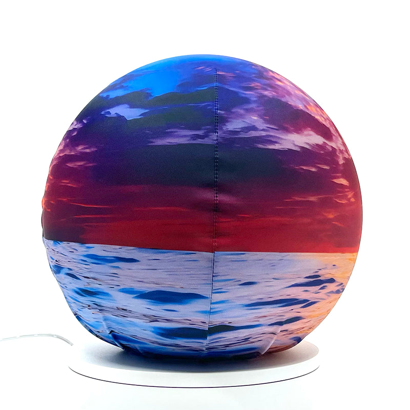 Fabric sphere cover featuring an ocean sunset design, wrapped around a 8.7" soccer ball, 9.5" basketball ball, or a 10" globe.